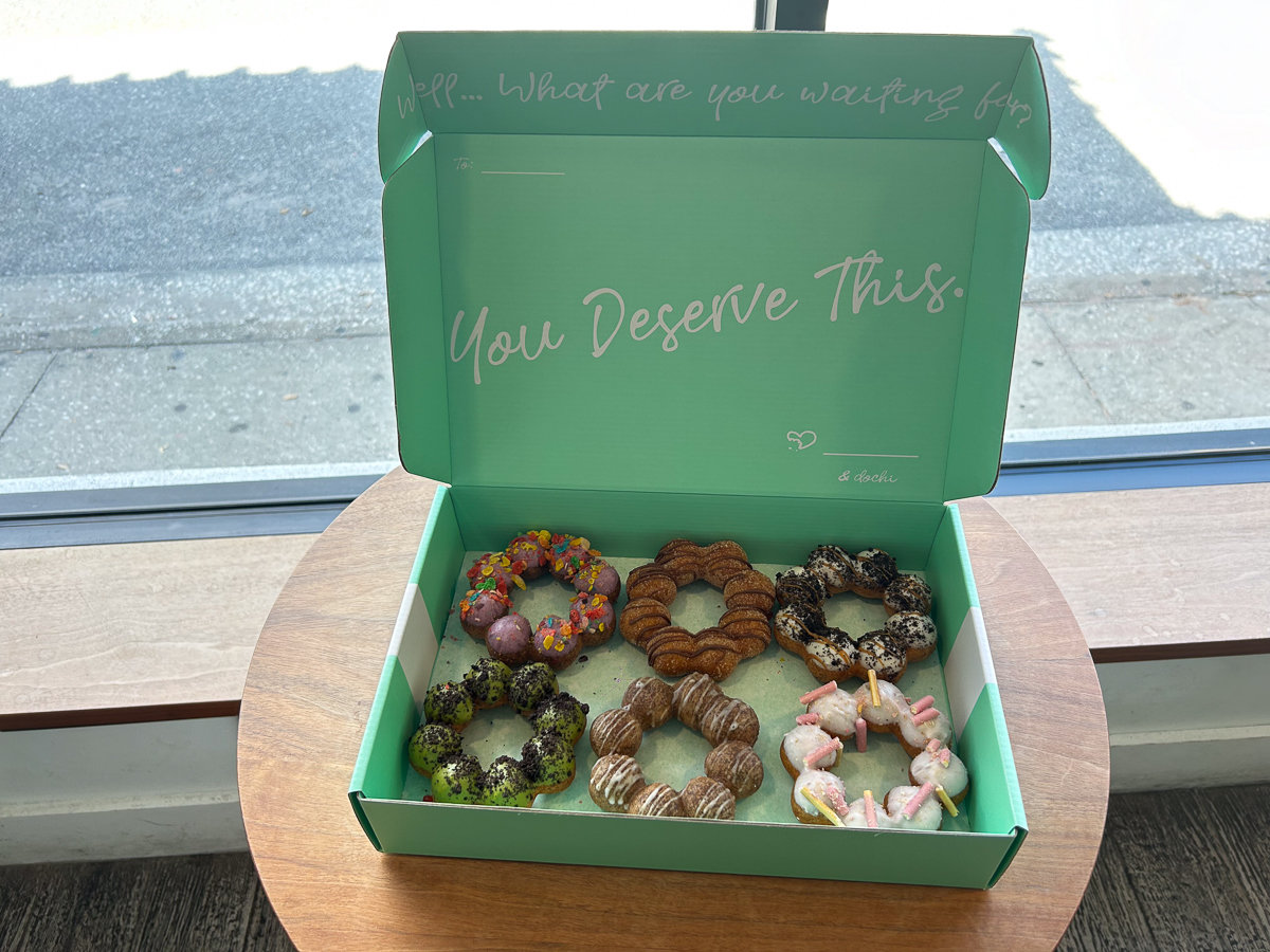 teal box with dochi donuts on a brown table